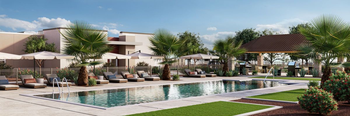 Outdoor swimming pool with lounge chairs, umbrellas, palm trees, and a covered seating area under a blue sky.