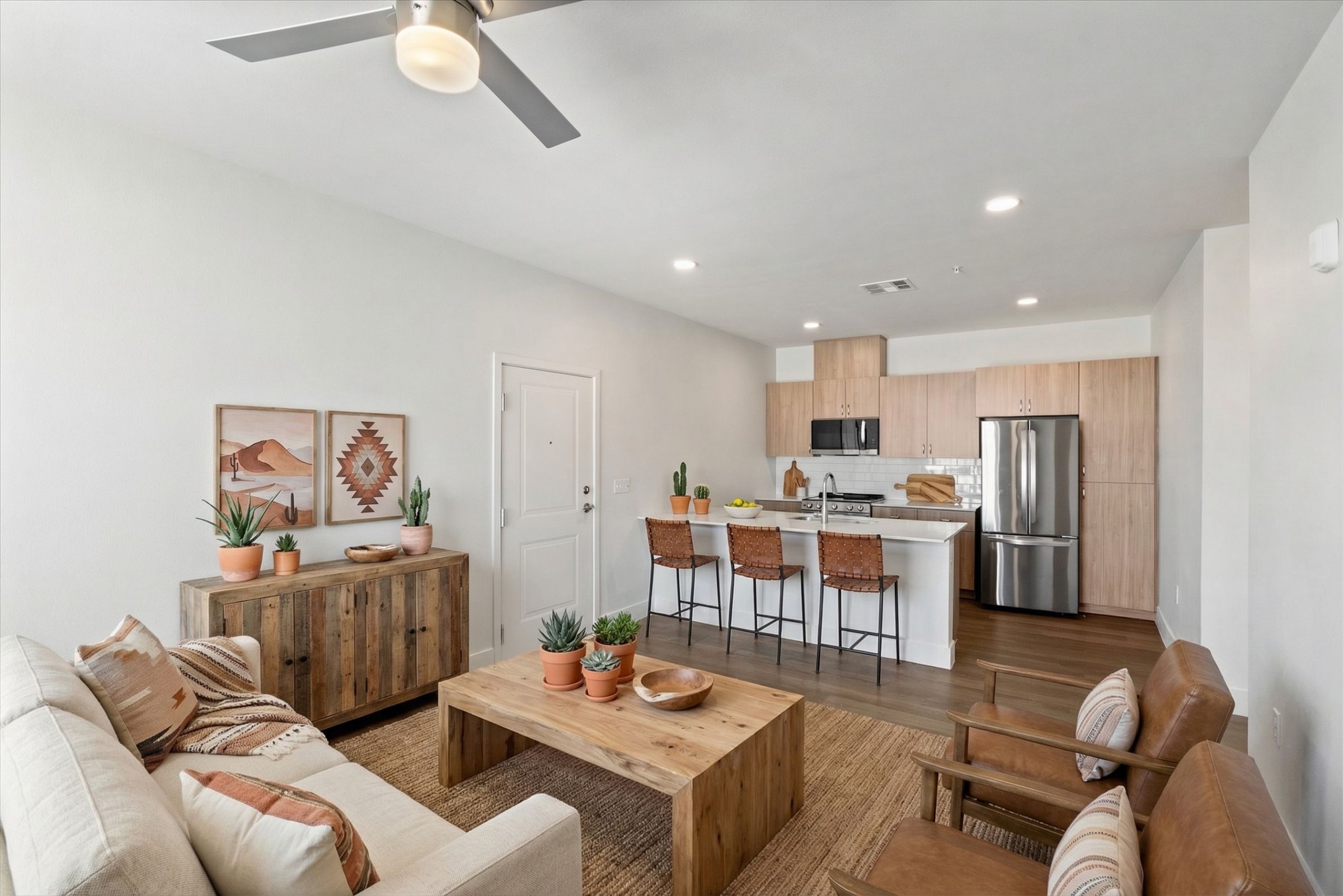 Modern kitchen with wood cabinets, stainless steel appliances, and a white countertop island.